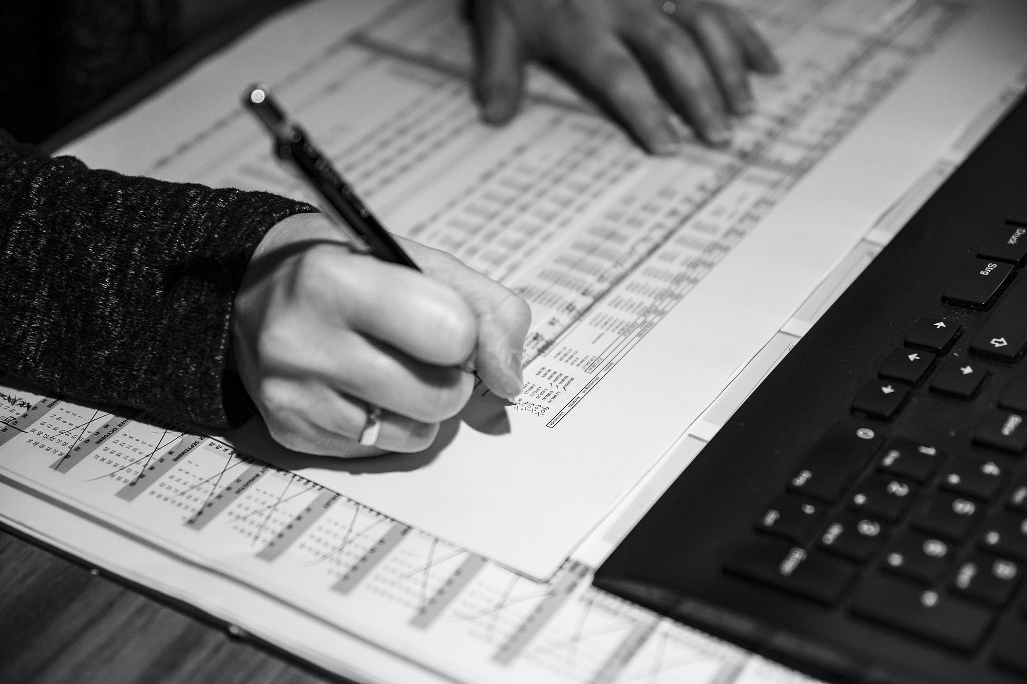 Handschriftliche Notiz auf einer Zahlenaufstellung neben einer Tastatur